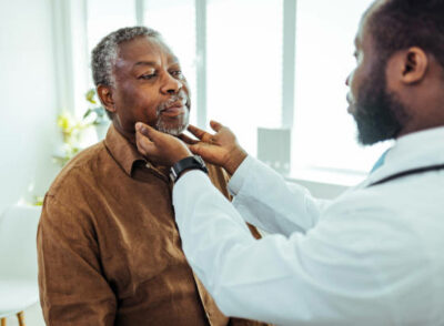Doctor doing throat examination on older man Doctor doing throat examination on older man