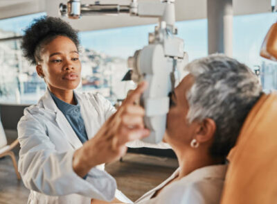 istockphoto-1495393006-612x612 Eye exam, vision and black woman with patient in optometry clinic for eyesight and optical assessment. Healthcare, optometrist consultation and doctor medical equipment, phoropter and lens for eyes
